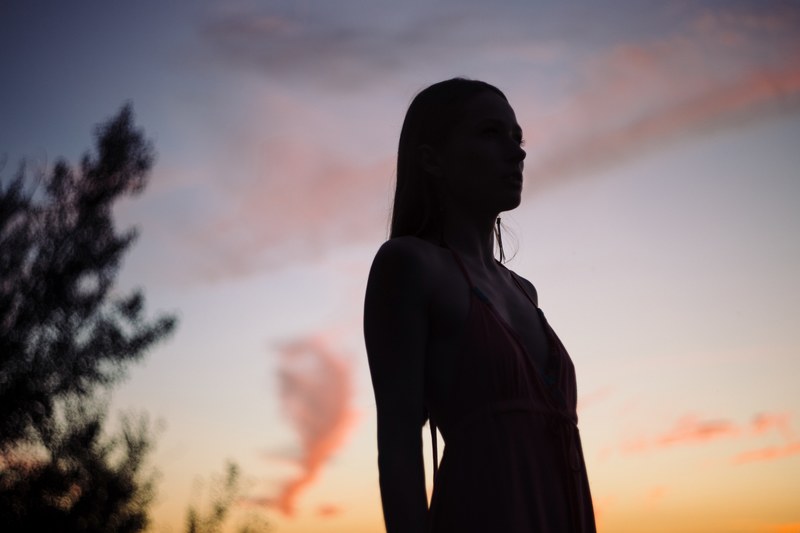 silhouette of woman with long hair standing during sunset in olsztyn, silhouette woman standing sunset 4k