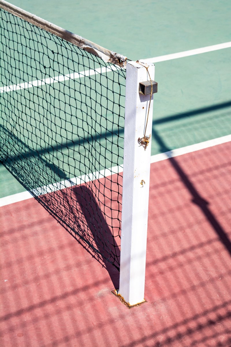 a focused shot of a post on one side of a tennis net, _tennis net white pole 4k