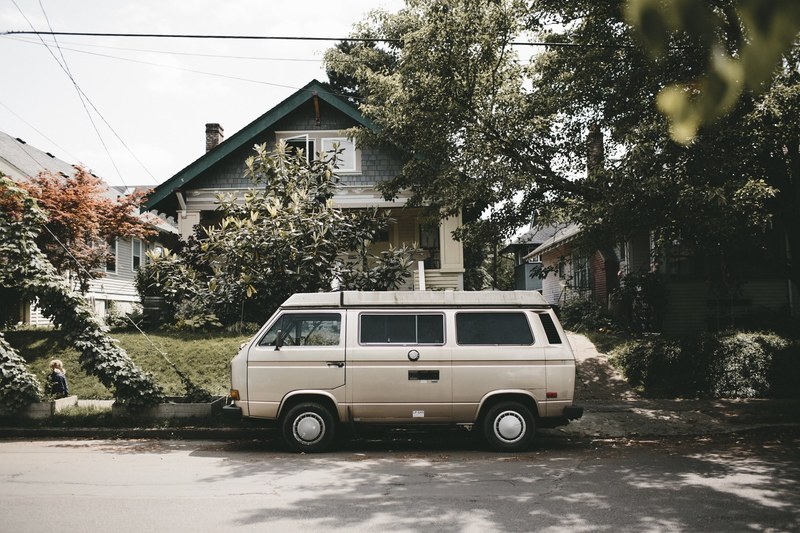 volkswagen camper van parked on the side of the street in front of a house, vw van life 4k