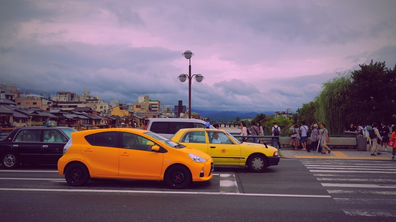 wide angle shot of cars behind a pedestrian crosswalk prominently featuring a yellow car in the foreground, _yellow car traffic 4k