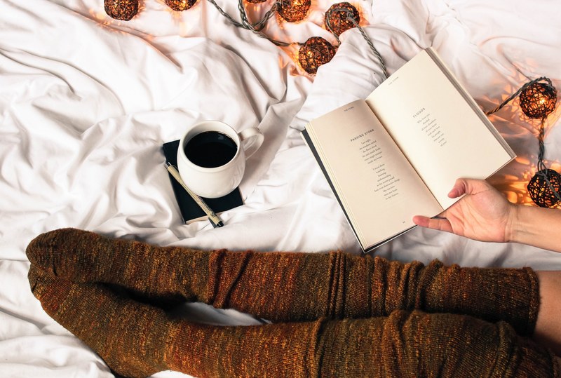 woman roads poetry book while drinking coffee 4k