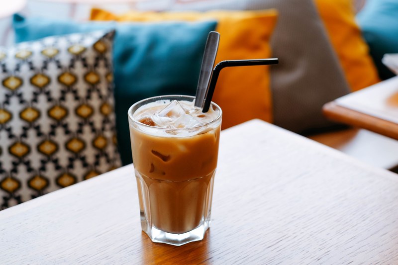 the macro view of a cup of latte with straw in it in coupi bar, cup of latte with straw 4k