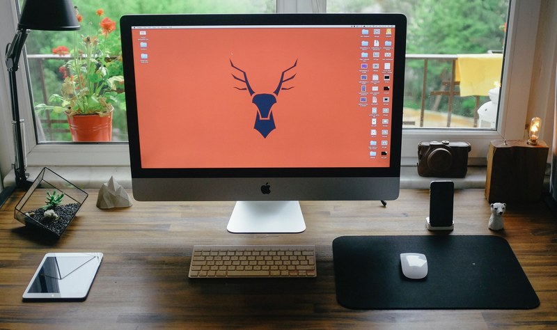 a computer workspace with an imac an ipad mini and a smartphone in a dock, window view 4k