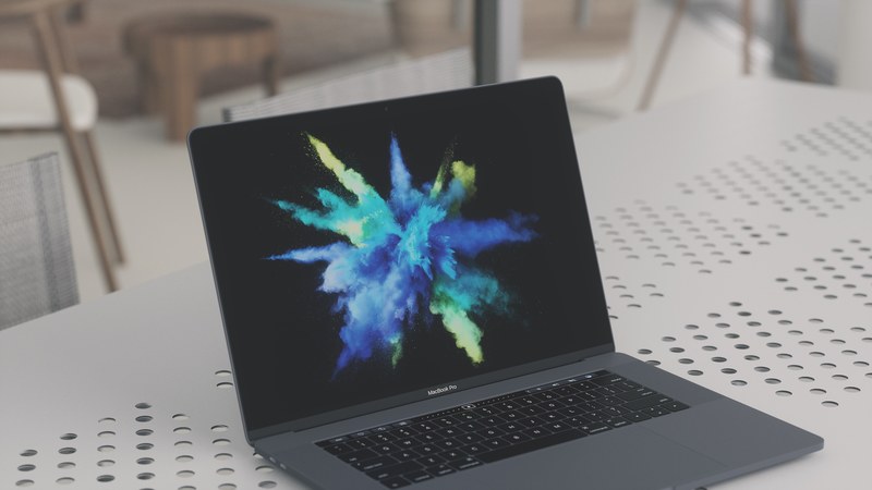an open macbook pro displaying a color burst on a perforated white surface, color burst laptop 4k
