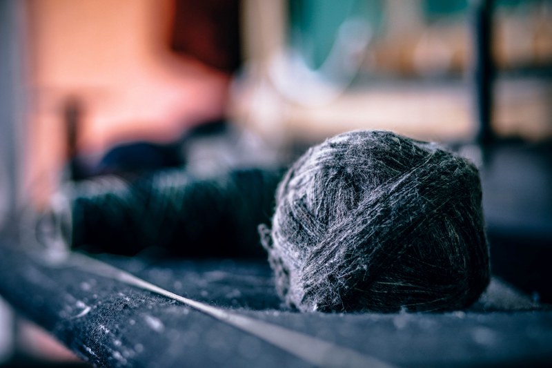 a ball of yarn besides spools of thread and fabric, fuzzy thread ball 4k
