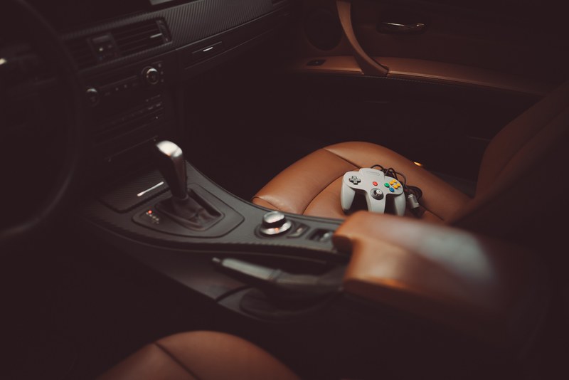 nintendo game controller sits on leather seat of car interior near dashboard, player 2 4k