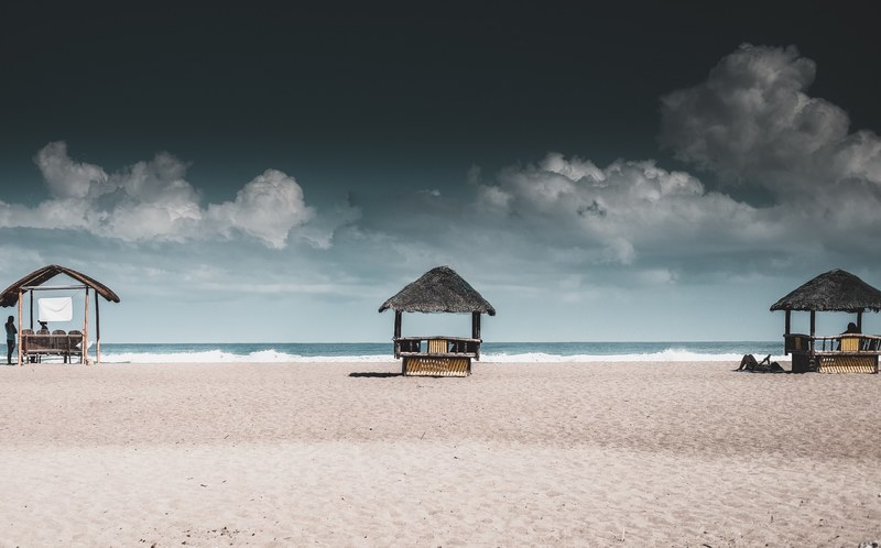 three beach huts on the sandy beach at the la union, chill under the sun 4k
