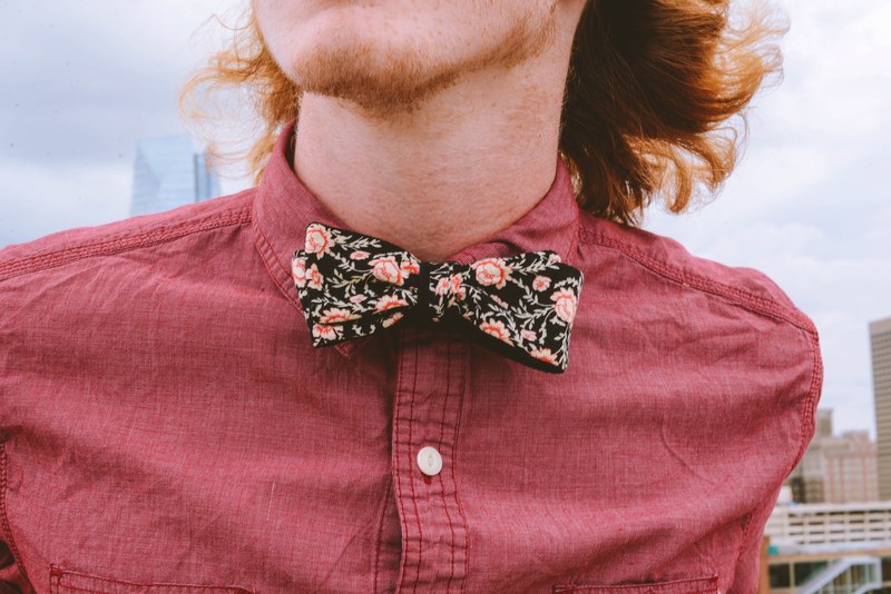 a red headed person in a floral bowtie against the downtown oklahoma city skyline, clad stache 4k