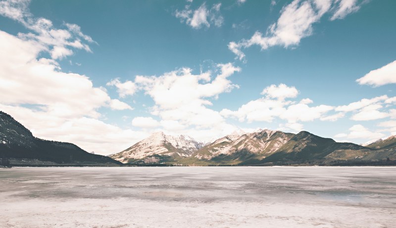 a low shot of the half frozen surface of a mountain lake, frozen lake in the mountains 4k