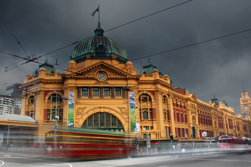 a blurred shot of traffic in motion on flinders street in melbourne, hustle and bustle in melbourne city 4k