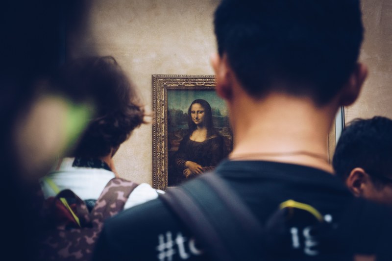 picture from behind of people viewing the mona lisa in louvre art gallery in paris, mona lisa being admired 4k