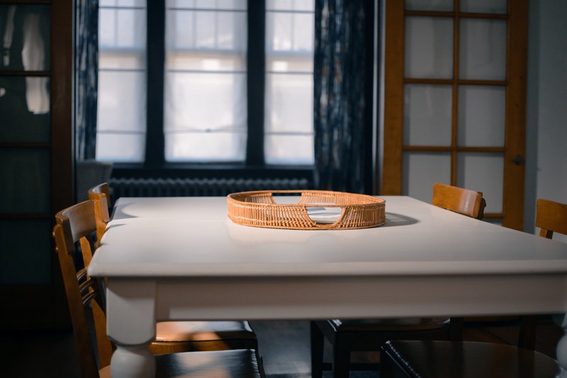 an empty rattan tray sits in the middle of a wooden dinning table set in st louis, st_ louis dining decor 4k
