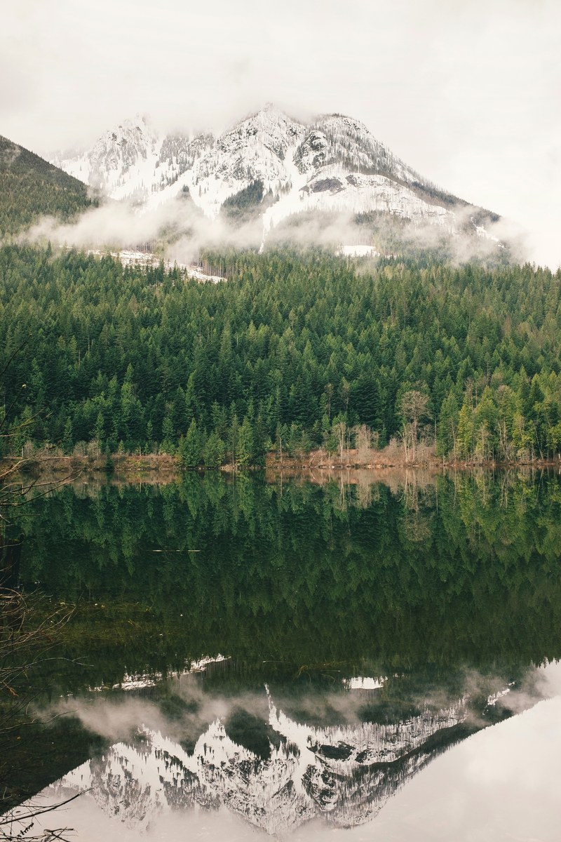 a snow topped mountain reflected in the surface of a lake, mountain reflection in a lake 4k