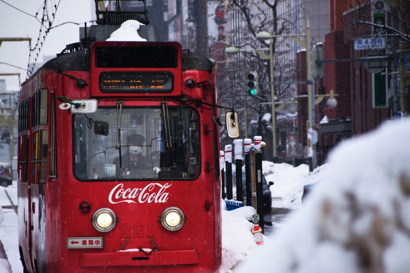 a trolleybus in sapporo japan with coca cola branding on the front, coca cola trolleybus in japan 4k