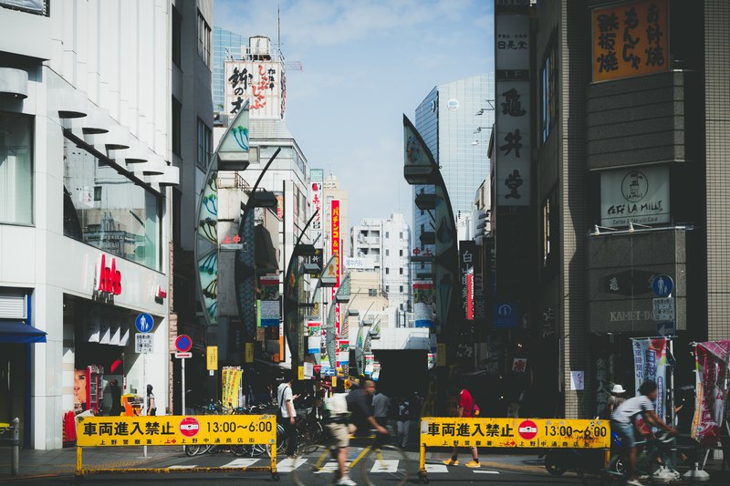 barricades block of a busy city street market in downtown japan, city crossing 4k