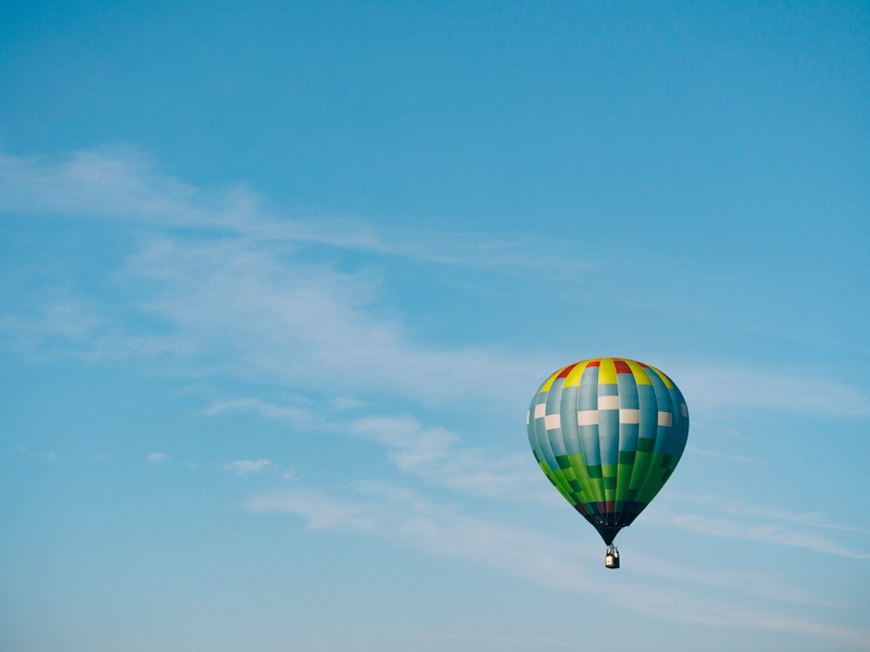 a colorful hot air balloon in the clear blue sky, colorful hot air balloon in flight 4k