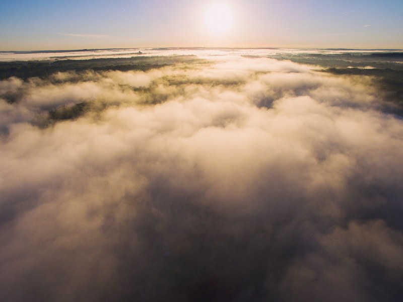 billowing clouds below a bright sunny sky, above the clouds 4k