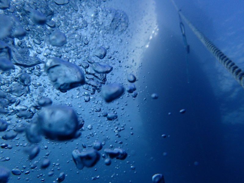 underwater view of air bubbles and a boat on the surface at panama city beach, ascending 4k