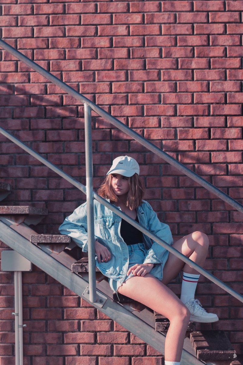 girl against red brick wall 4k