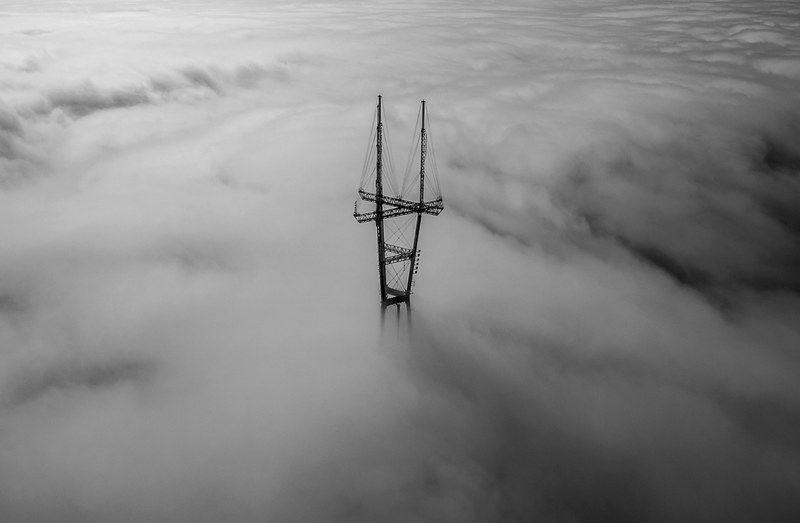 black and white drone shot of sutro tower emerging from thick clouds, monochrome drone sutro tower 4k