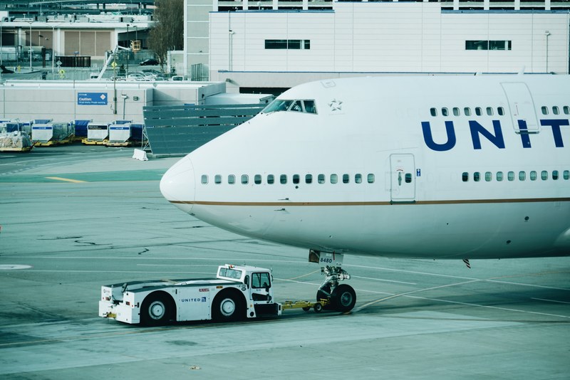 the front of an united airplane on the runway of san francisco international airport, pull the giant 4k
