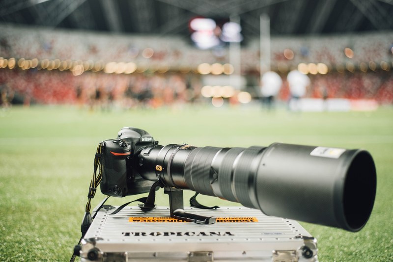 a long lens camera on a steel crate in a soccer field, nikon camera field sports 4k
