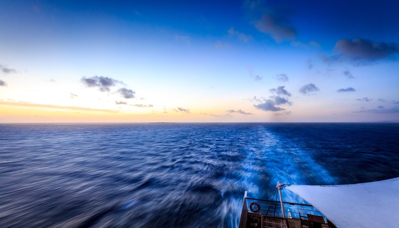 a view from the stern of a boat on its wake in deep blue ocean, dark blue wake 4k