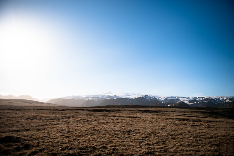 a barren plain with snowy mountains on the horizon, barren mountain field 4k