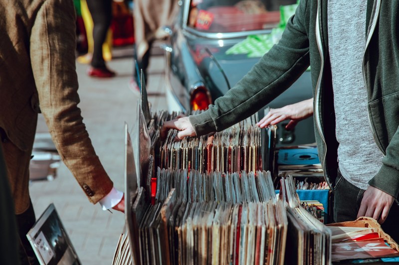 people browsing vinyl records at a stall on the street, retro vibes 4k
