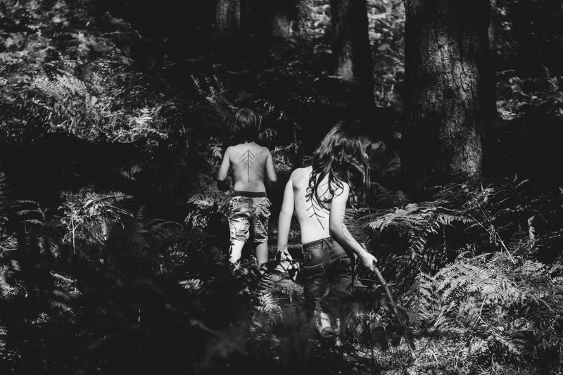 two shirtless children walking through a forest in black and white, kids in woods in monochrome 4k