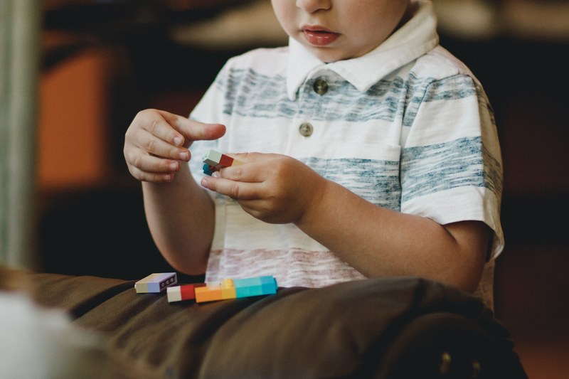 a little boy playing with different colored legos, lego boy 4k
