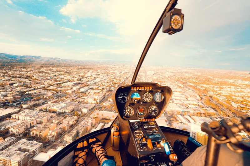 inside the cockpit of a helicopter flying above a busy city downtown, flying above the city 4k