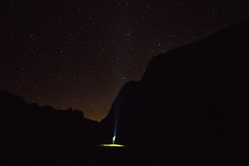 eerie spotlight on a person in a dark field on a starry night, alien abduction 4k
