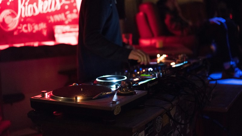 a dj working their turntable at a club in klaipda, spin that record 4k