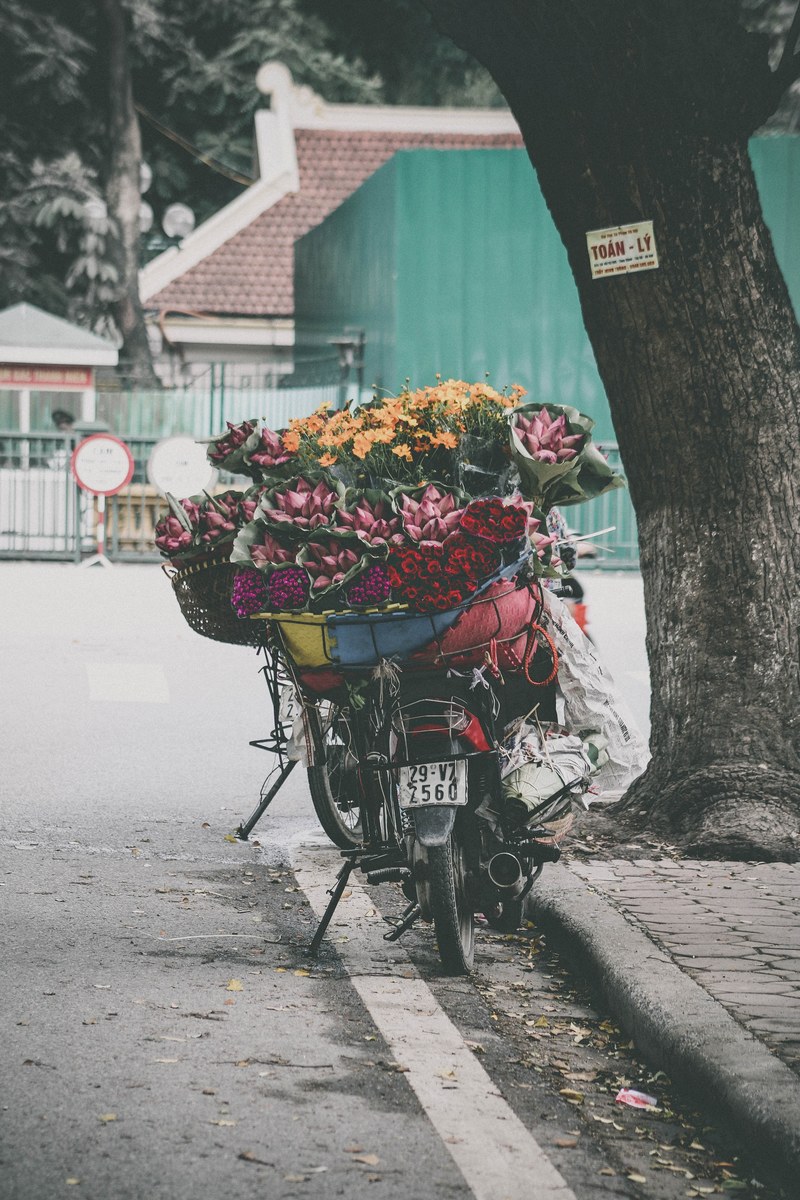a delivery bicycle is parked outdoors full of flower bouquets in thy khu, flower delivery bicycle 4k