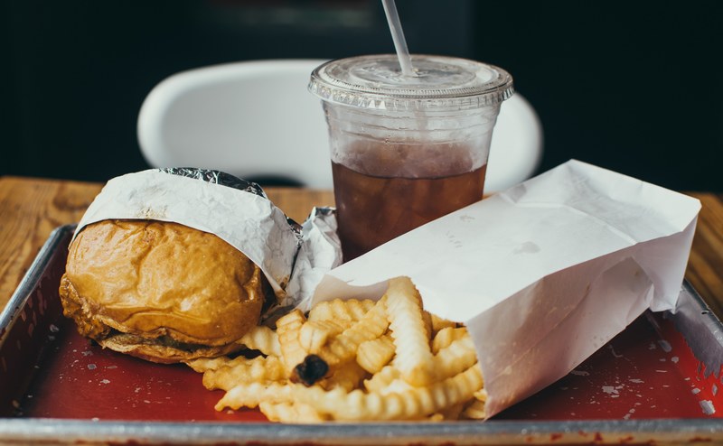 fast food tray with a greasy burger crinkle cut fries and soda, fast food for lunch 4k