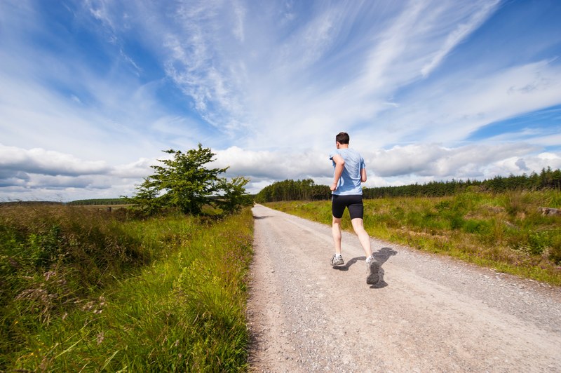 a man running on a dirt path through the grass, trail running 4k