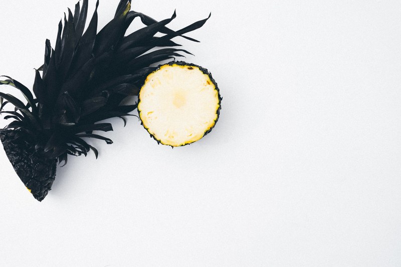 a pineapple sliced in half with the lower half showing the flesh, _pineapple in half 4k