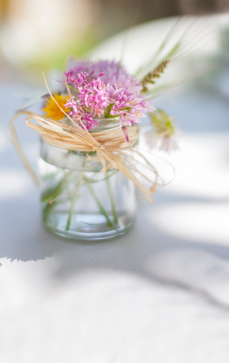 pink flower in glass jar tied with twine on white table in spring, from the country to the table 4k