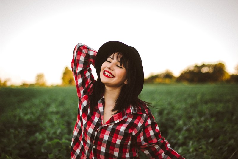 an asian woman in a plaid shirt and black hat posing for a picture in a field, _asian plaid shirt 4k