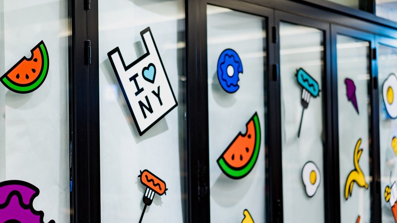 windows with dark frames and cartoon fruit stickers in columbus circle, columbus sticker windows 4k
