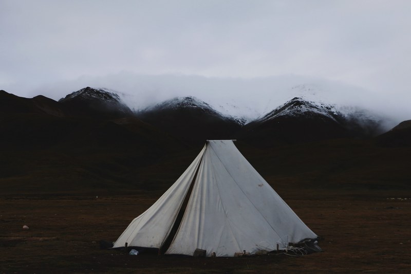 white tent set up in the grass with snowy mountains in the background, tent 4k