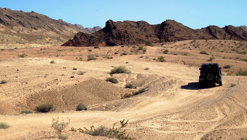 jeep truck drives through rough terrain of the desert in las vegas, black jeep desert vegas 4k