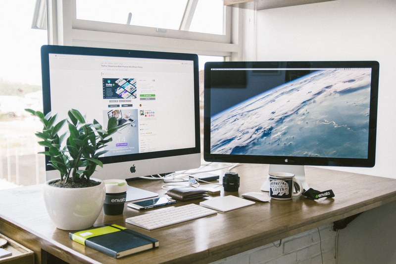 a dual monitor setup on a brown desk, _dual monitor display 4k