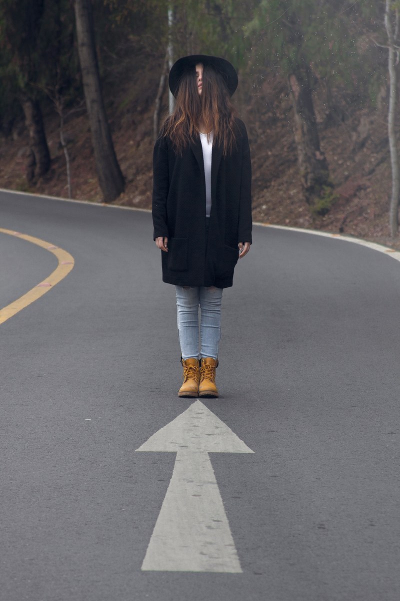 a woman with hair covering her face stands on a road a painted arrow facing her, woman female lady and caucasian hd, 4k