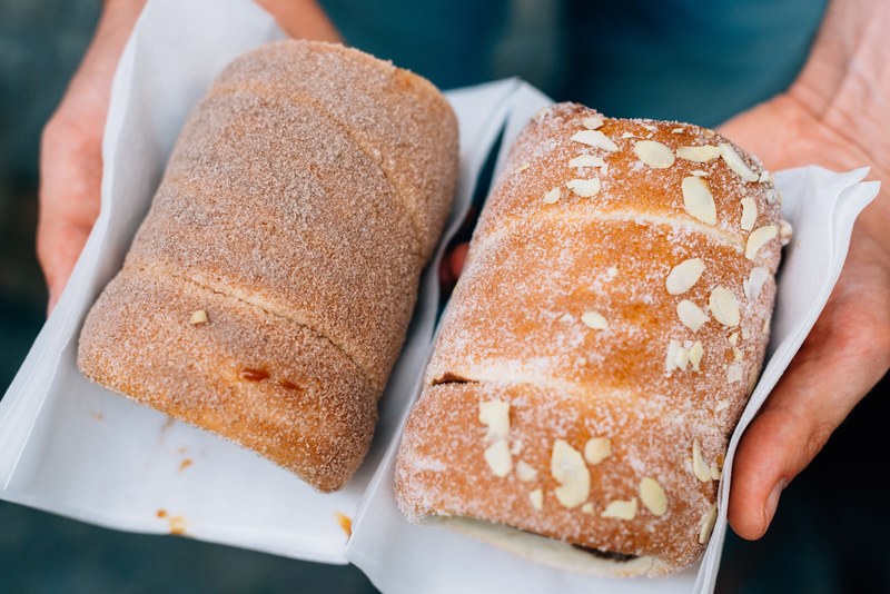 hands hold two loaves of freshly baked sweet bread, a day in prague 4k