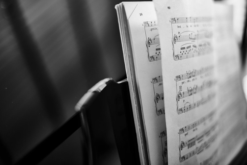 a black and white shot of an open music score on a stand, black and white music score 4k