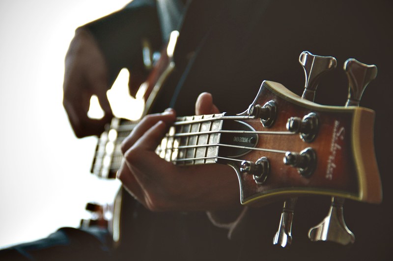 a close up of a persons hands strumming the guitar, hands on a guitar neck 4k
