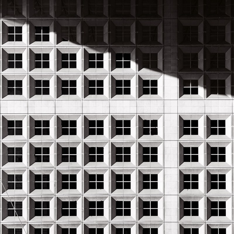 black and white shot of urban building windows with shadow grande arche de la defense, la tour 4k