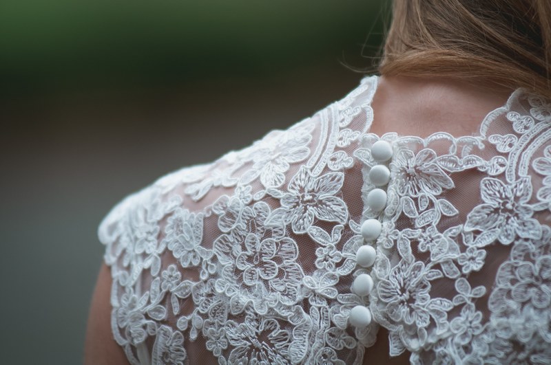 close up of a woman wearing a lace button up wedding dress, a brides gown 4k